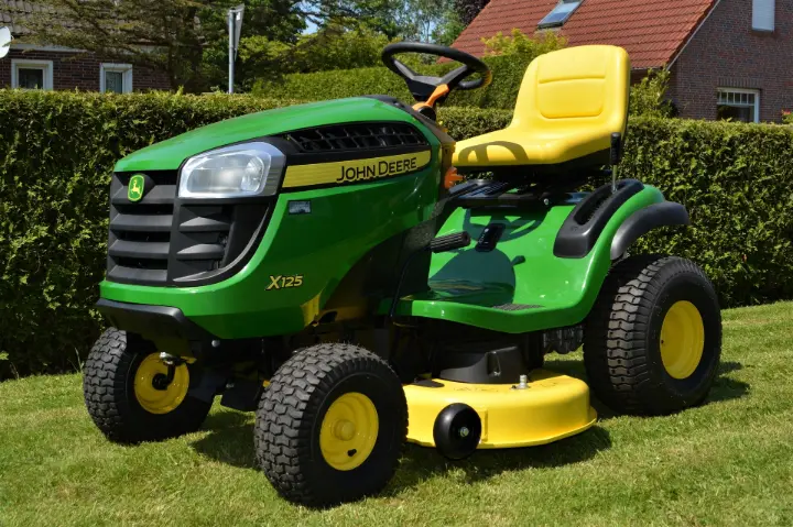 A garden tractor mowing a large lawn, perfect for basic landscaping and garden care. A garden tractor mowing a large lawn, perfect for basic landscaping and garden care.
