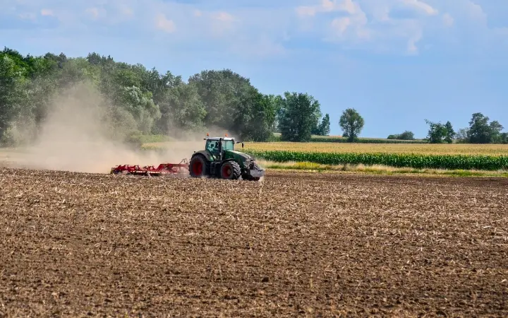 A modern tractor using an auto-steer system for precision planting in a large field.