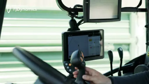 A modern tractor equipped with the FJD AT2 Auto Steer System navigating a farmland with GPS precision.