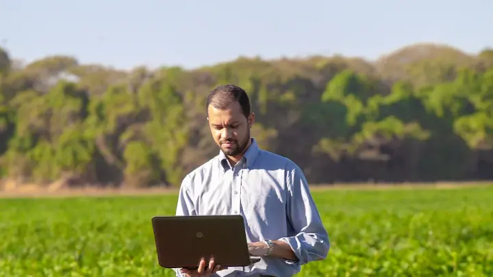 Farmer using farming software in the field for farm management