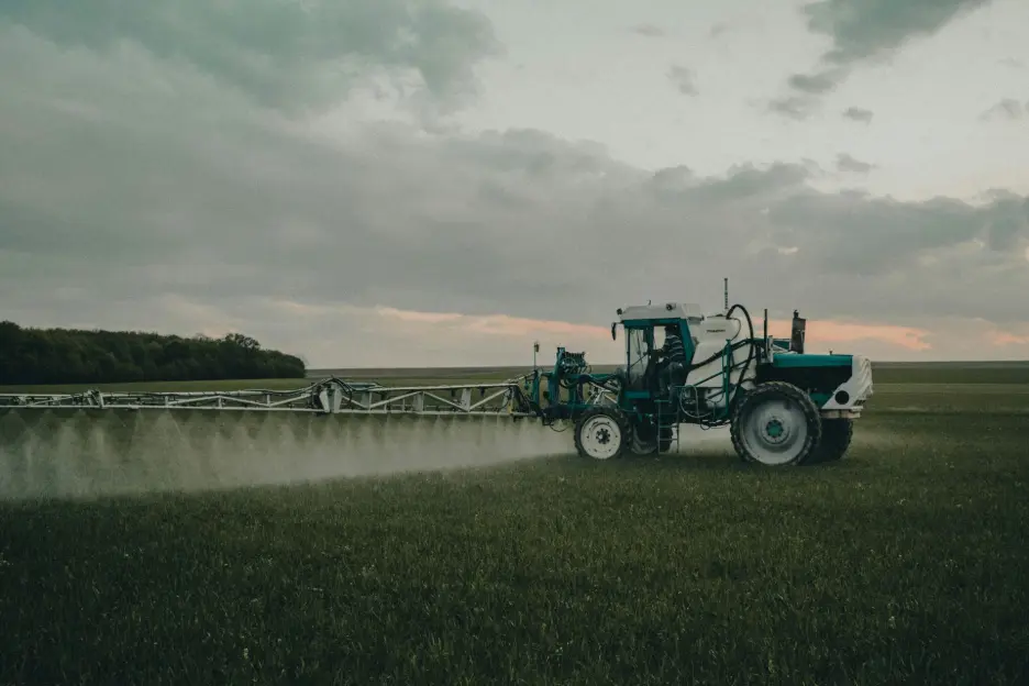 Tractor spraying crops in open field