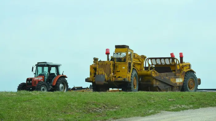 Tractor and heavy machinery on grassy field