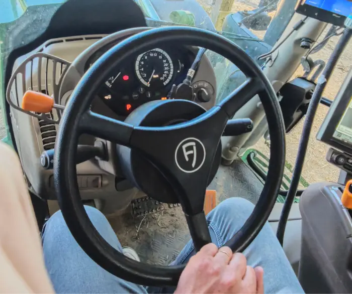 A hand holding the steering wheel