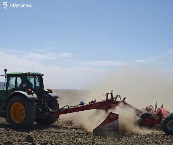 Tractor plowing a dusty field