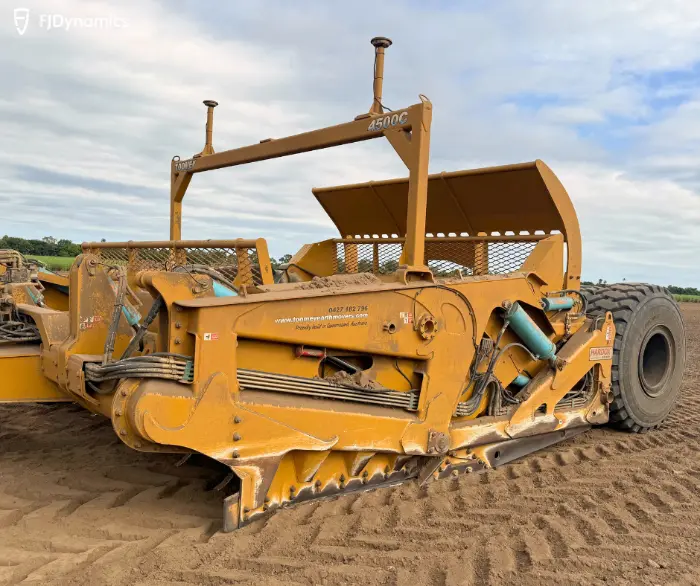Yellow farm equipment on muddy field