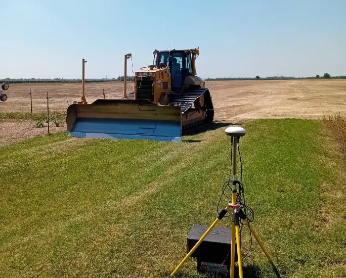 Bulldozer and surveying equipment on field