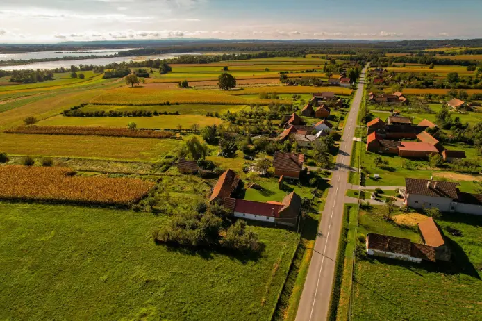 Aerial view of neatly aligned farmlands enabled by smart tractor auto steer system, improving field efficiency and land utilization