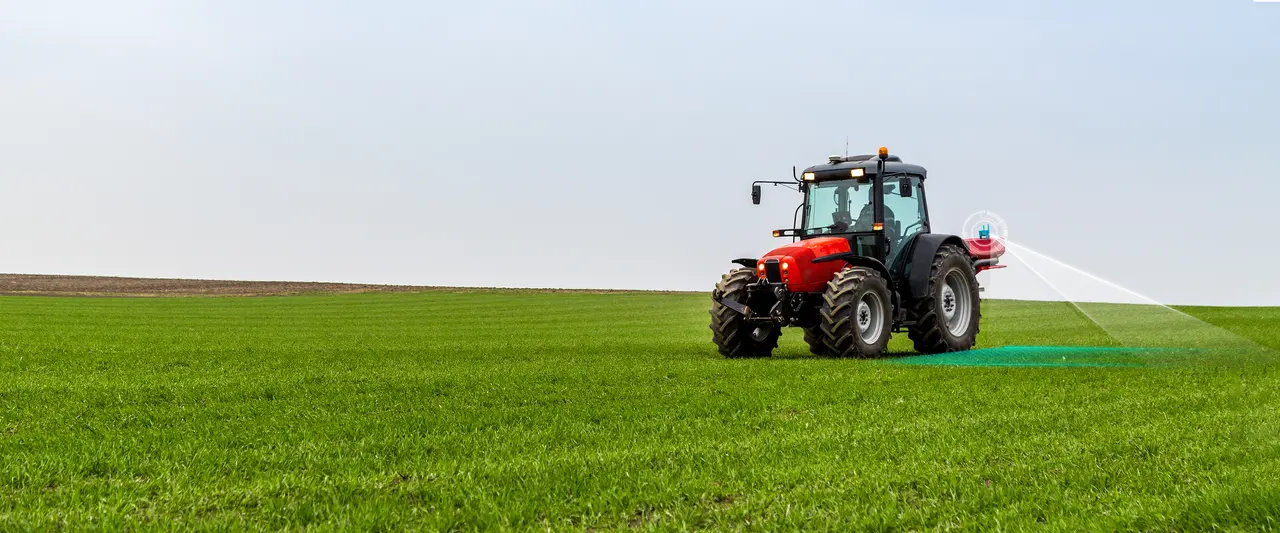 Precision agriculture in action: A red tractor performs a targeted spraying operation across a lush green field, showcasing technology designed to protect crops and boost yields efficiently.